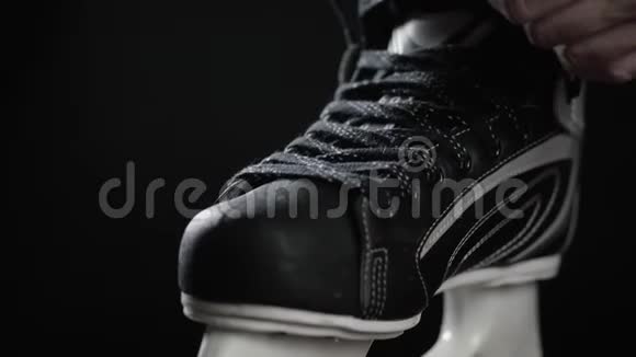 冰球运动员溜冰鞋带黑色背景近距离手准备比赛加拿大冰视频的预览图