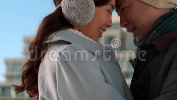 可爱的亚洲情侣穿着冬装拥抱在一起视频的预览图