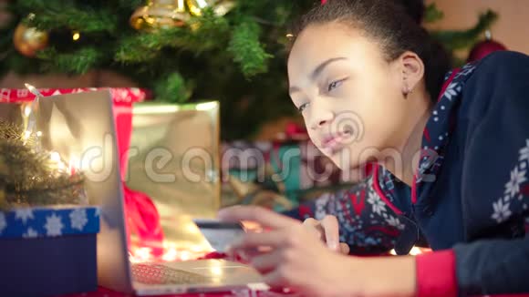 在圣诞前夜在网上购物的年轻黑人女性的特写镜头视频的预览图