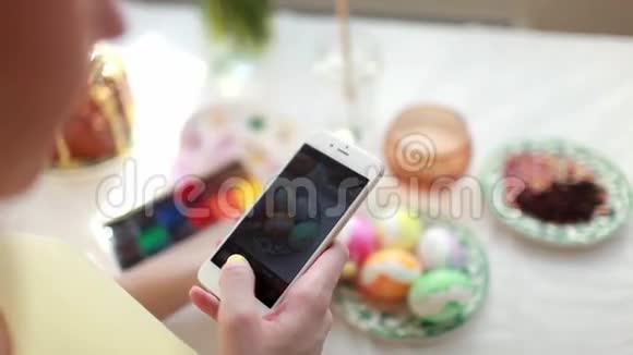 复活节假日传统技术和人的概念接近女人的手与智能手机拍照视频的预览图