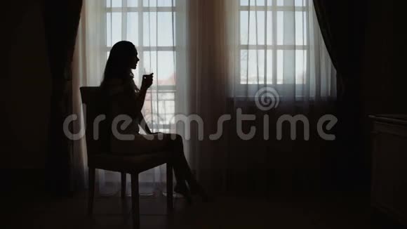 年轻的商务女性在她的酒店卧室里放松在窗口喝一杯红酒在美国视频的预览图