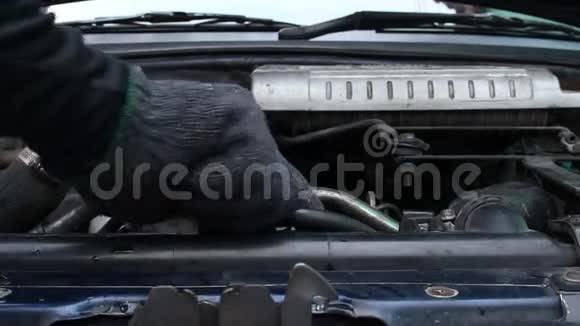 机械师在汽车散热器中添加冷却剂视频的预览图