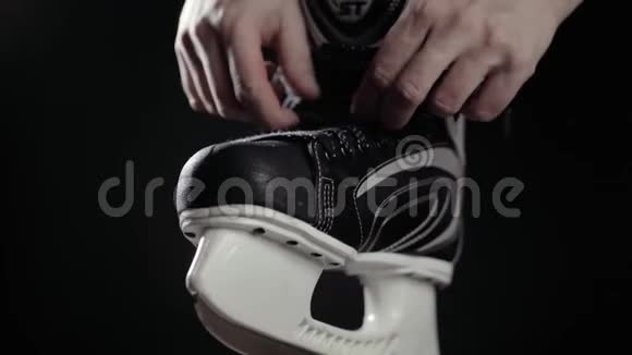 冰球运动员溜冰鞋带黑色背景近距离手准备比赛加拿大冰视频的预览图