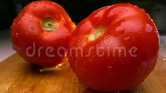 木切割板上的红色西红柿正在喷水4K实时镜头视频的预览图