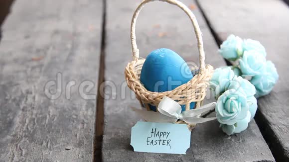 复活节快乐蓝鸡蛋放在乡村的桌子上还有一个带标签的篮子复制空间视频的预览图