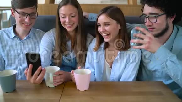 年轻的朋友坐在咖啡馆里喝咖啡交流愉快慢动作视频的预览图