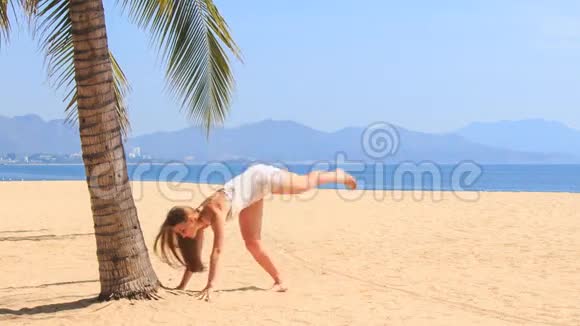 1金发碧眼的女孩在海滩上摆姿势拍掌视频的预览图