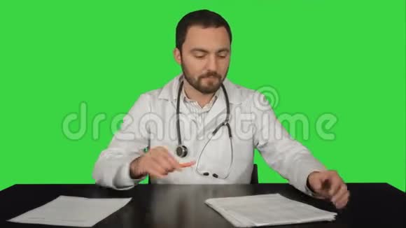 愤怒的医生在绿色屏幕上摆着桌子视频的预览图