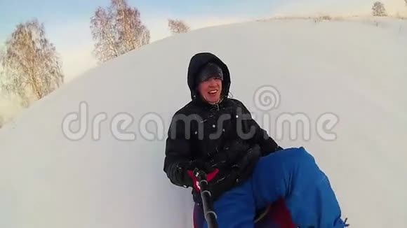 快乐的人骑着雪管在雪道上微笑慢动作冬天的雪景户外运动视频的预览图