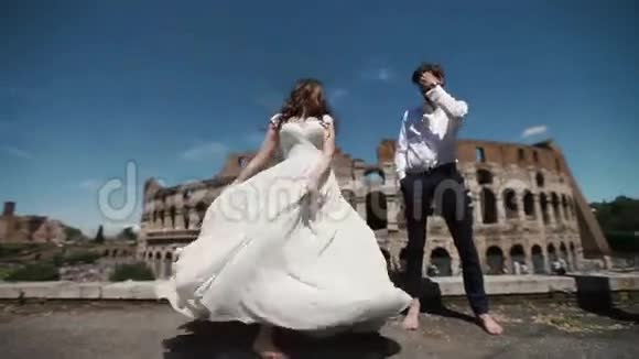 罗马的一对婚礼夫妇在体育馆幸福的新郎看着他的新娘穿着她的婚纱跳舞意大利的蜜月视频的预览图