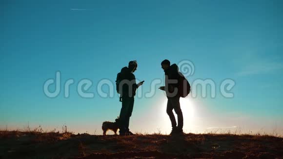 团队合作两名游客徒步旅行男人和狗带着背包在日落时去徒步旅行慢动作视频智能手机视频的预览图