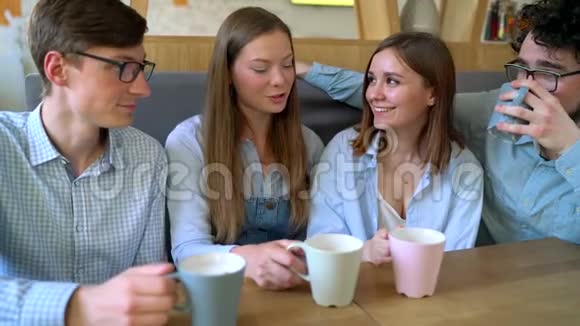年轻的朋友坐在咖啡馆里喝咖啡交流愉快慢动作视频的预览图