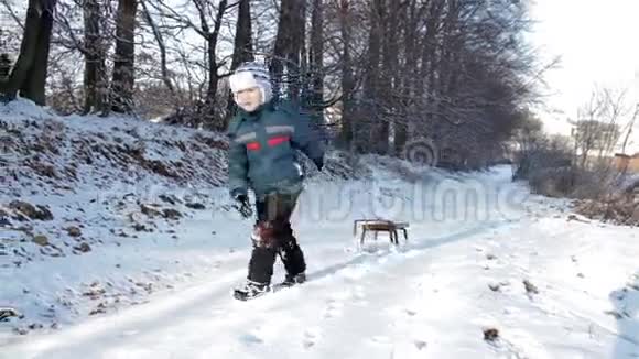 男孩拉着雪橇在山上视频的预览图