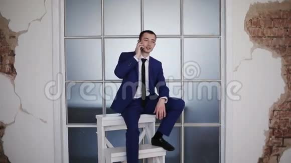 商人坐在象征性的职业阶梯上打电话视频的预览图
