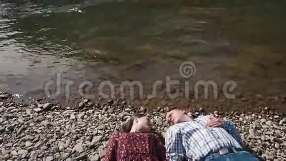 在河边的一对年轻夫妇英俊的男人弯下腰然后轻轻地吻她的嘴唇视频的预览图
