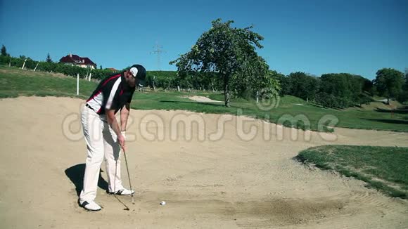男子高尔夫球手在沙地高尔夫球场练习击球视频的预览图