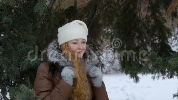 一个美丽的时尚模特微笑和看镜头红色的长发冬天飘雪慢动作视频的预览图