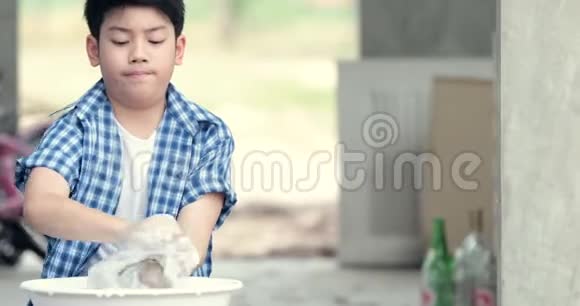 亚洲男孩用手洗毛巾泰国小男孩在家做家务视频的预览图