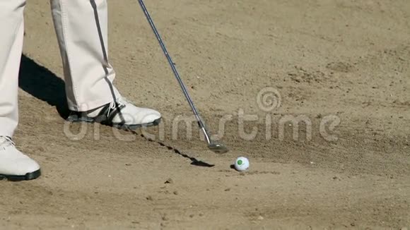 在高尔夫沙场上打白色高尔夫球的高尔夫球手近距离射击视频的预览图