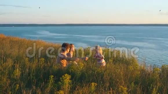 幸福的一家人在河边看日落视频的预览图