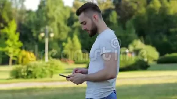 一个拿着平板电脑站在公园里的人视频的预览图