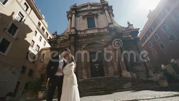 在圣尼古拉达托伦蒂诺教堂附近的罗马婚礼情侣接吻美丽的新娘和时髦的新郎轻轻地视频的预览图