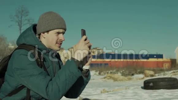 一个男人手里拿着智能手机坐在户外视频的预览图