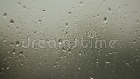 雨滴在雨天的玻璃窗上流视频的预览图