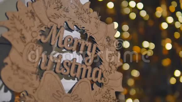 圣诞彩灯背景上印有圣诞快乐字样的木制标牌视频的预览图