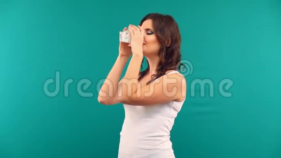 美丽的女孩在绿色背景下喝着一杯酸奶牛奶视频的预览图