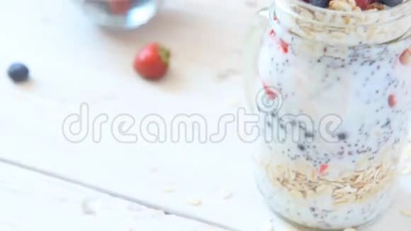 自制健康酸奶与辣椒种子和草莓在罐子里视频的预览图