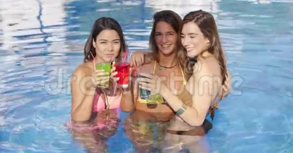 三个快乐的女朋友在泳池里视频的预览图