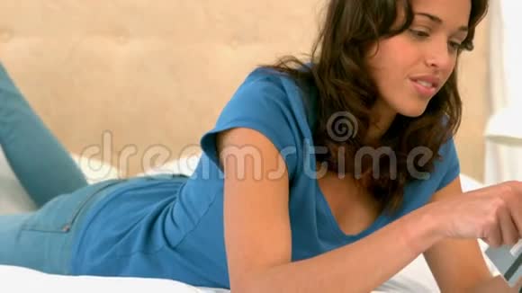 女人用平板电脑在床上购物视频的预览图