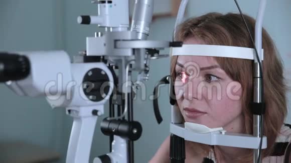 年轻女子用现代医疗设备检查眼睛视频的预览图