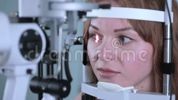 年轻女子用现代医疗设备检查眼睛视频的预览图