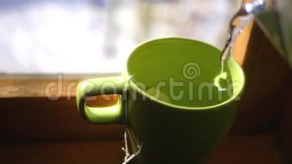 在靠近窗户的杯子里倒热水冲泡美味的茶蒸汽漩涡HD1920x1080视频的预览图