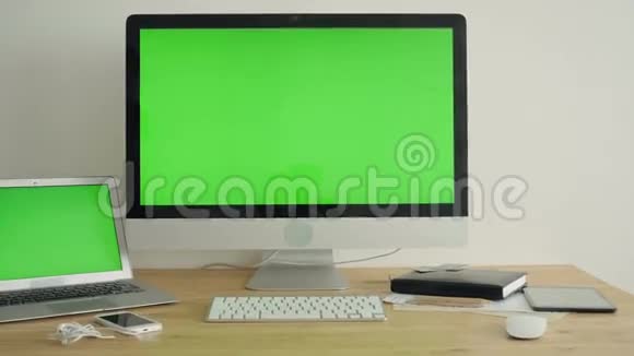 桌上有绿色屏幕的电脑显示器视频的预览图