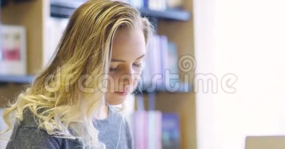 图书馆内使用笔记本电脑的女学生的特写视频的预览图