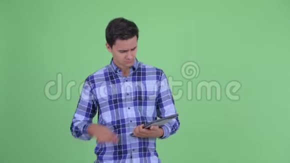 快乐的年轻英俊的时髦男人在用数码平板电脑说话视频的预览图