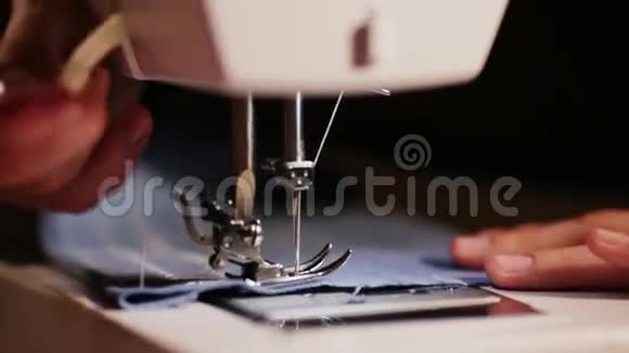 女孩在缝纫机上缝衣服蓝色和黄色的特写针视频的预览图