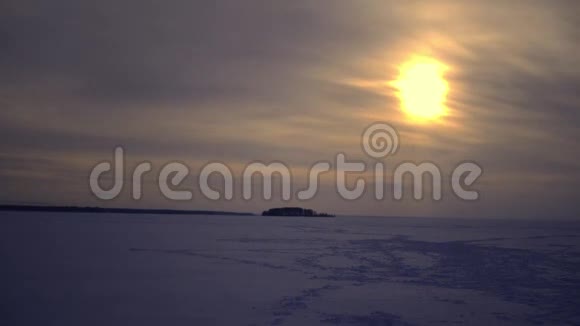 冬天的日落在冰封的湖面上直到地平线时间流逝视频的预览图