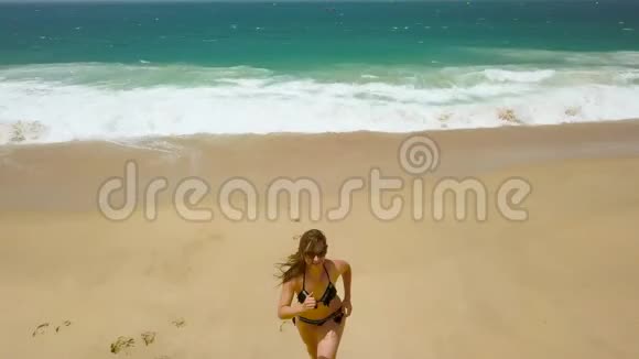 海滩比基尼女人无忧无虑地从海滩上的水中奔跑葡萄牙美丽的海洋海岸视频的预览图
