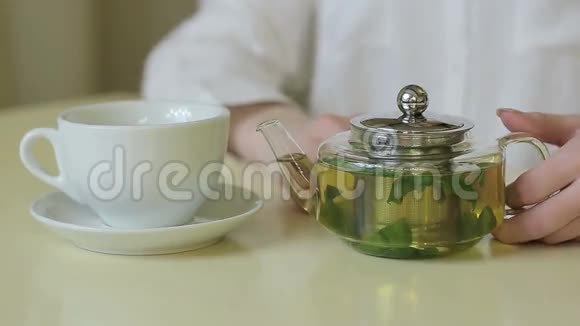 女人从茶壶里倒绿茶视频的预览图