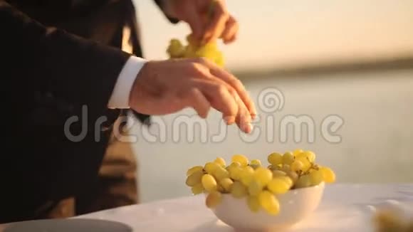 准备浪漫晚餐的男人把葡萄放进碗里视频的预览图