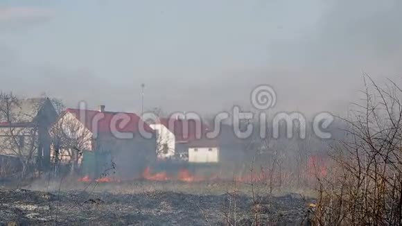 在农村居民点旁边烧干草大火攻占了一座房子视频的预览图