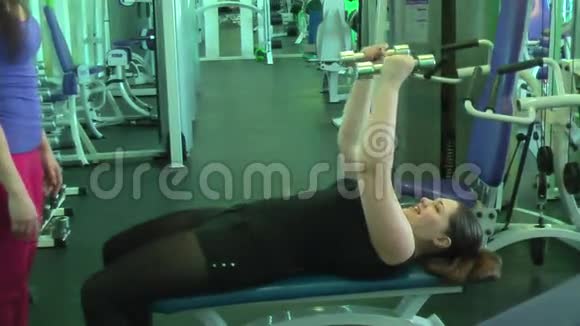 健身妇女用哑铃锻炼视频的预览图