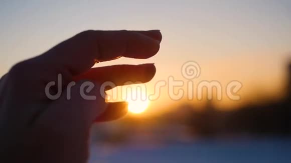 手中的太阳女人手抓太阳的背景美丽的夕阳在地平线上自然视频的预览图
