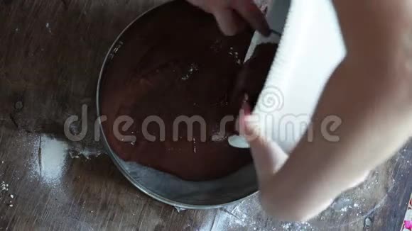 女人往烤盘里倒巧克力面团的俯视图视频的预览图