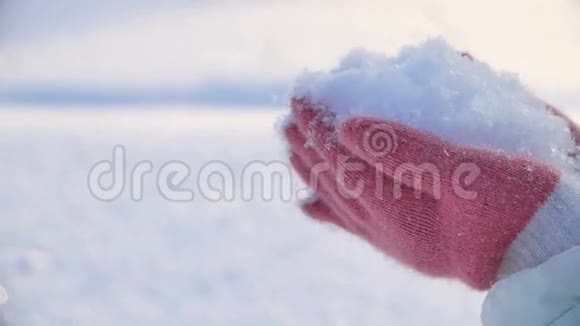 年轻女子手捧雪吹着雪视频的预览图