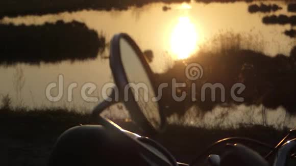 日落时摩托车后视镜美丽的行动近湖视频的预览图